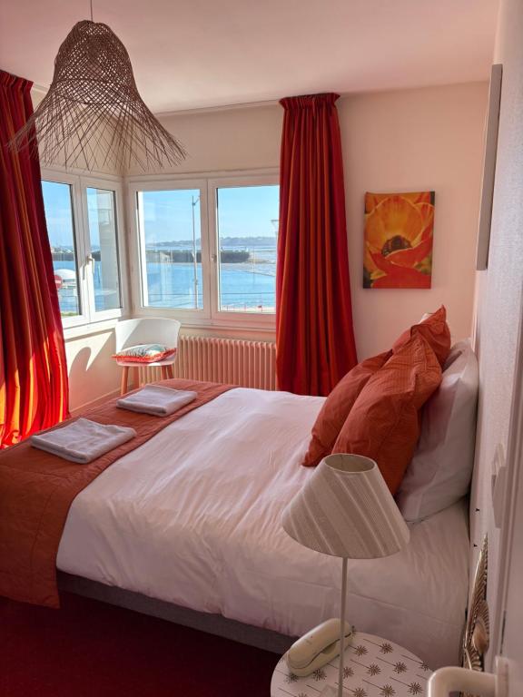 a bedroom with a bed with a view of the ocean at La parenthèse du port in Perros-Guirec