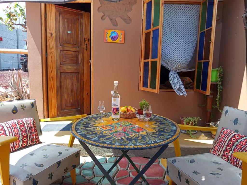 a table with a bowl of fruit and two chairs at Ecoalbergue Retablos Perú Habitación YING YANG in Lunahuaná
