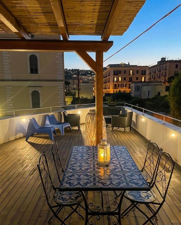 a patio with a table and chairs on a deck at Casa con terrazza esclusiva vicino al mare Domus Neapolis Happy Holiday in Naples
