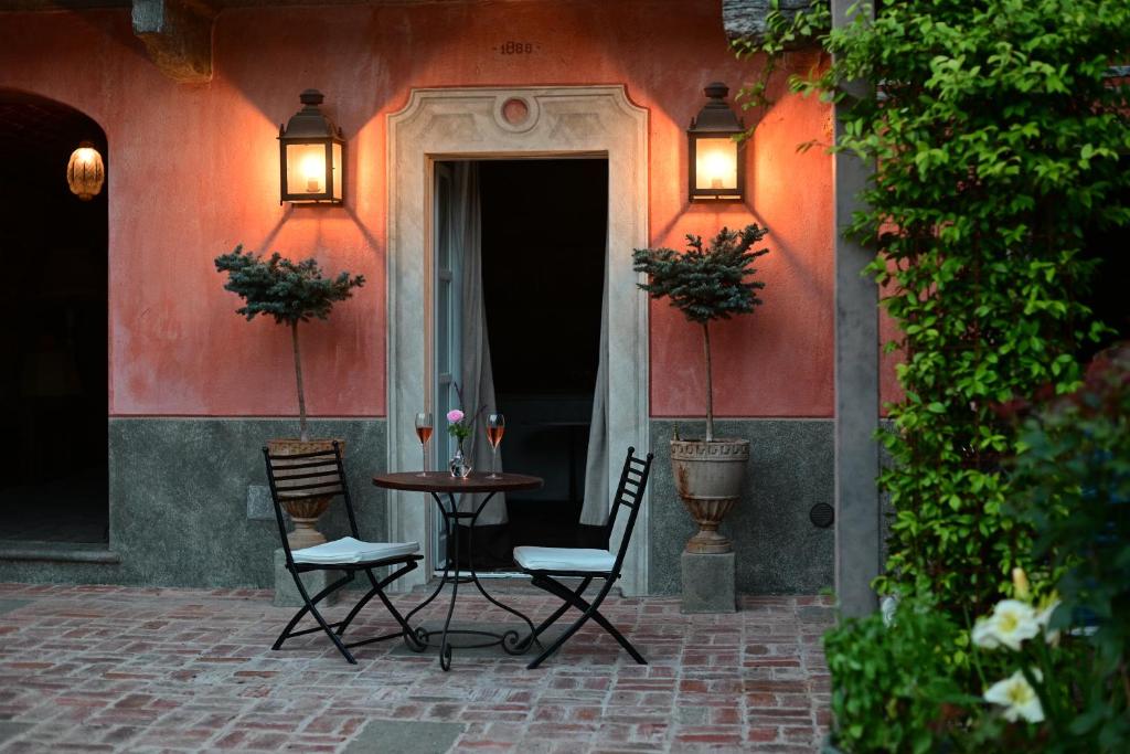 a patio with two chairs and a table in front of a building at Relais Conac 1888 - Luxury B&B - Adults Only in Castelnuovo Don Bosco