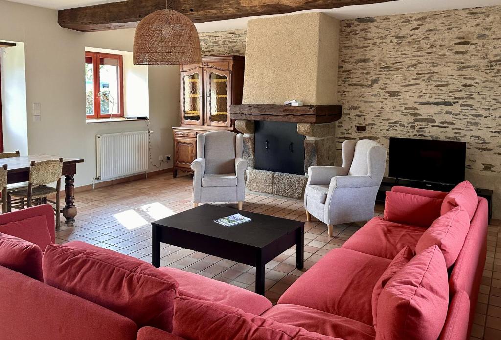 a living room with a red couch and a table at AppartCosy 27 Epine in Châteaubourg