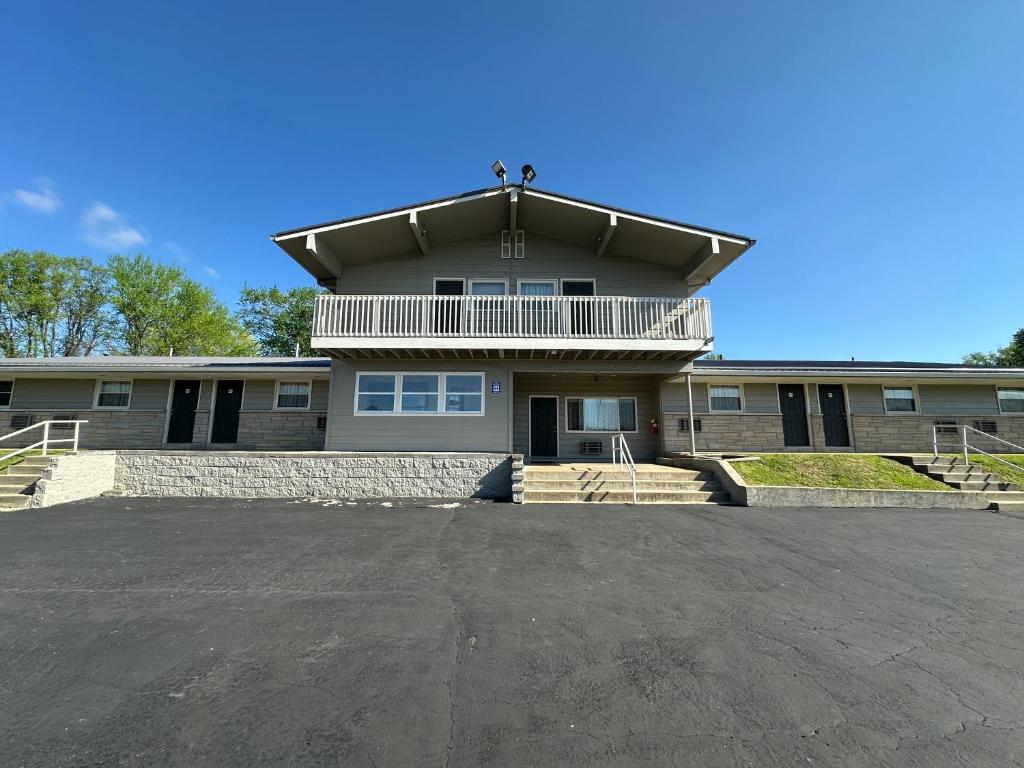 a large house with a balcony on top of it at Budget Inn - Cambridge in Fairdale