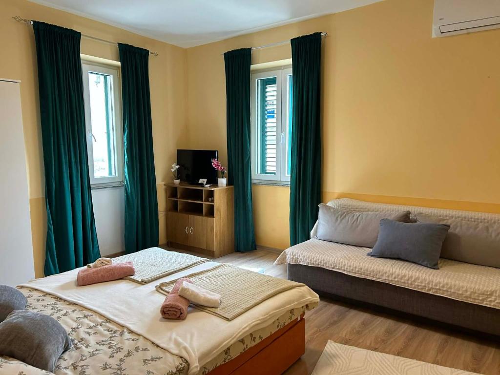 a bedroom with two beds and green curtains at Apartment Bačvice in Split