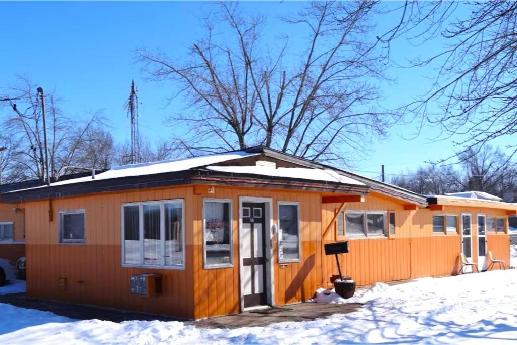 an orange house with snow on the roof at Sparta Motel Near St Louis- Mississippi River IL in Sparta