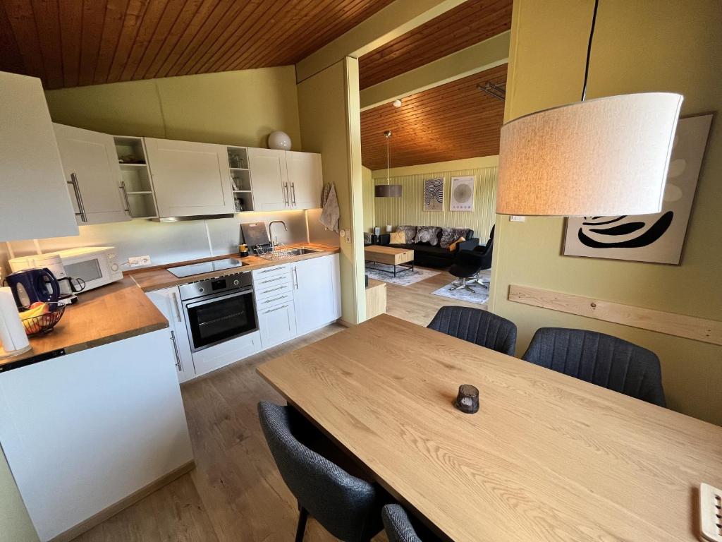 a kitchen and dining room with a wooden table at DeichLand117 in Butjadingen
