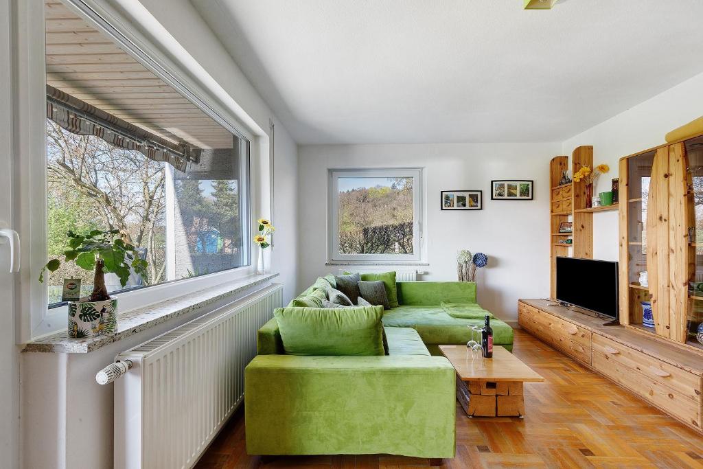 a living room with a green couch and a window at Ferienwohnung glüxnest in Bernstadt