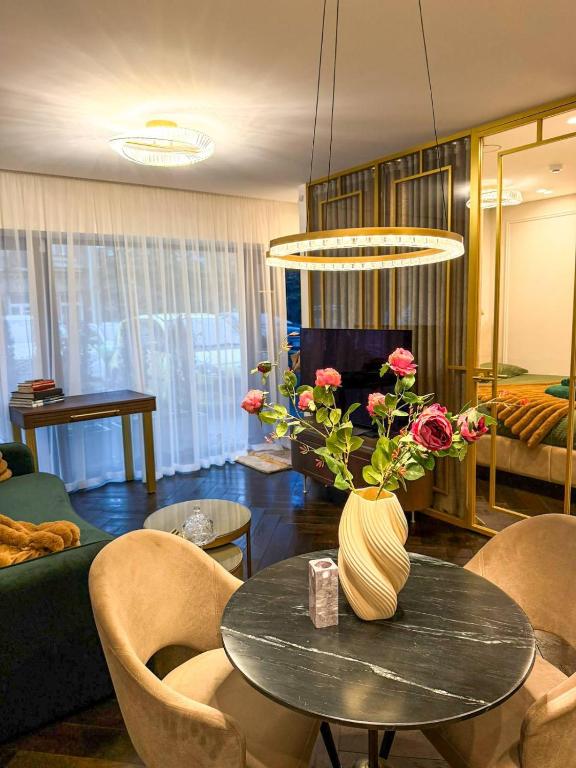 a living room with a table with a vase of flowers at Vilnius Luxurious flat in Vilnius
