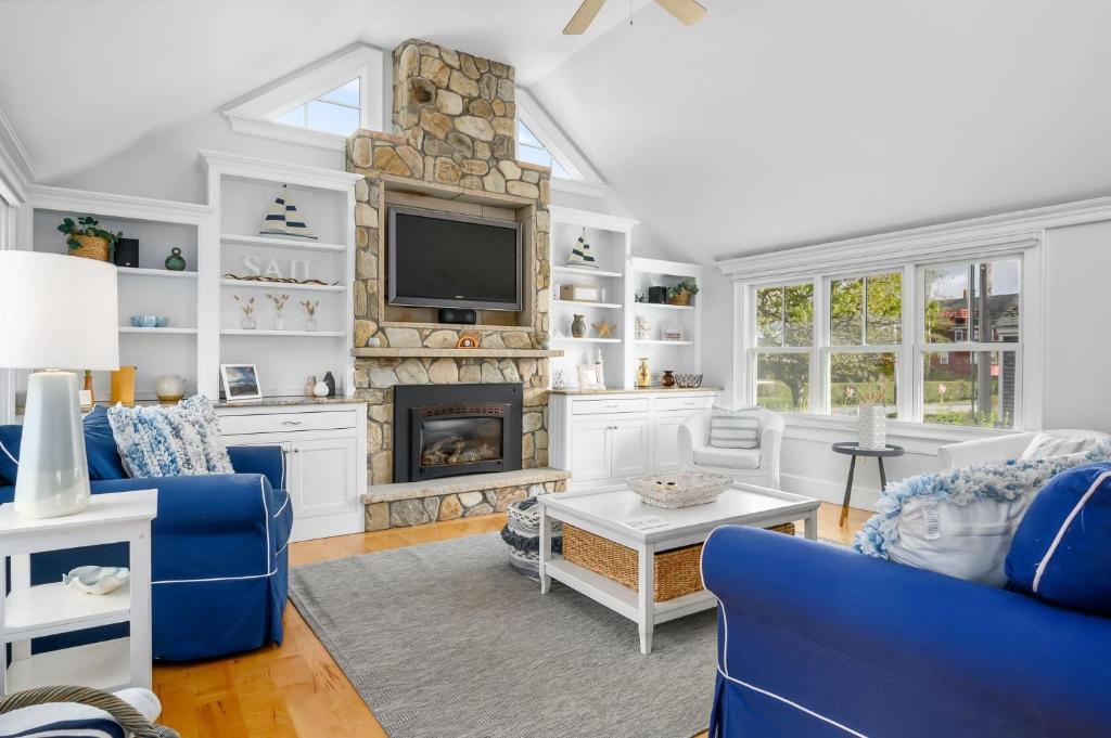 a living room with a blue couch and a fireplace at Walk to Beach and Town, Hot tub, Sleeps 8, Pet Friendly in Chatham