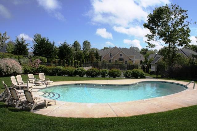 a swimming pool with lounge chairs in a yard at Captain's Row: Pool, Tennis Chatham Charm in Chatham