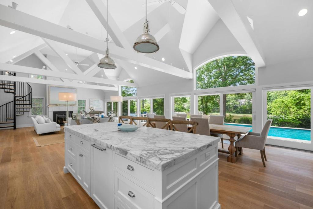 a large white kitchen with a dining room and living room at Bay Breeze Escape—Pool, Game Room Views in Centerville