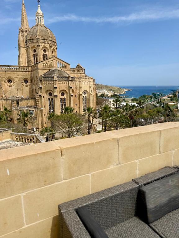 a view of a cathedral from the wall of a building at Azure Dome Residences in Għajnsielem