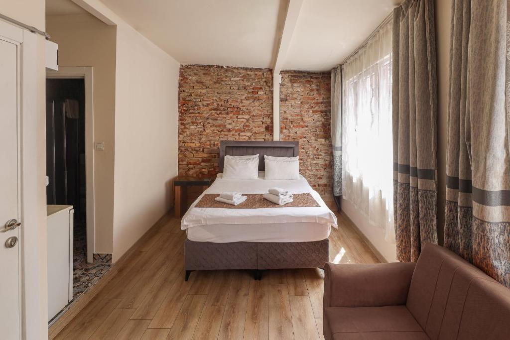 a bedroom with a bed and a brick wall at Angela Inn Boutique in Istanbul