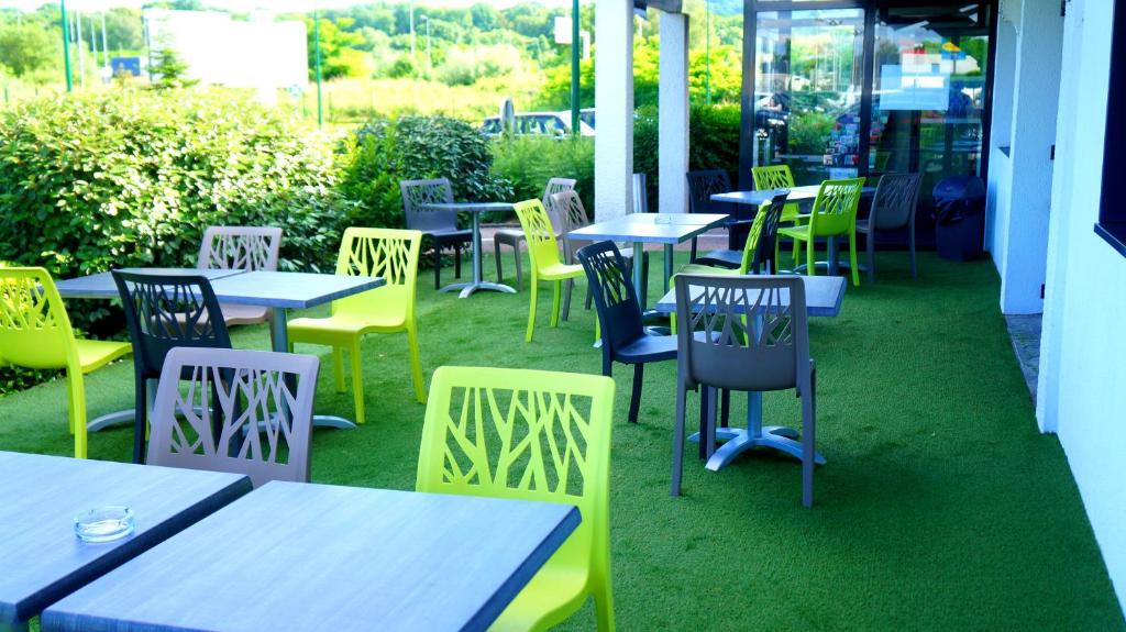 a group of tables and chairs in a restaurant at ibis budget Metz Sud in Augny
