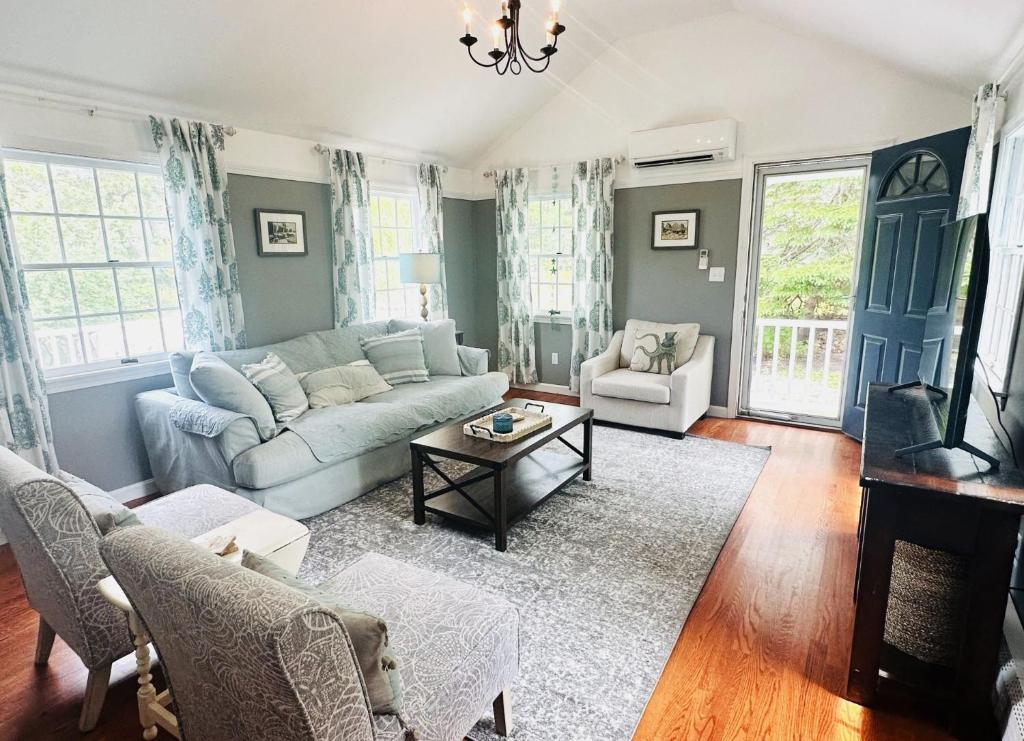 a living room with a couch and a table at Beach Glass—Space, Fun Furry Friends Welcome in Brewster