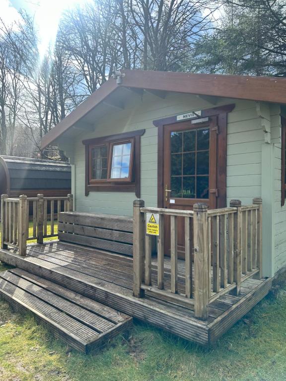 a tiny house with a porch and a sign on it at By The Way Campsite, Trekker, Nevis in Tyndrum