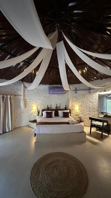 a bedroom with two beds and a large ceiling at Tanas in Khawāsa