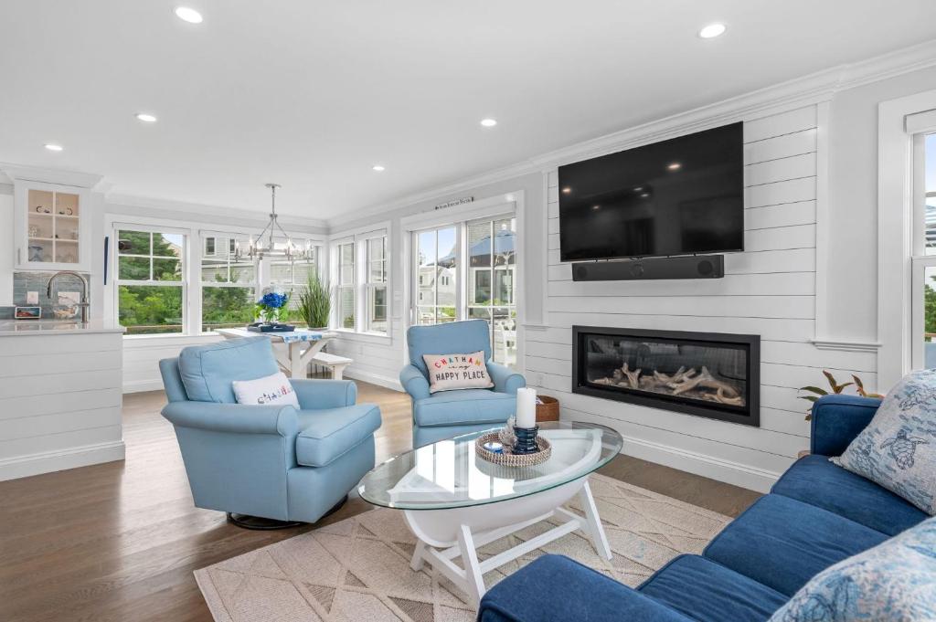 a living room with blue chairs and a fireplace at Happy As A Clam in Chatham