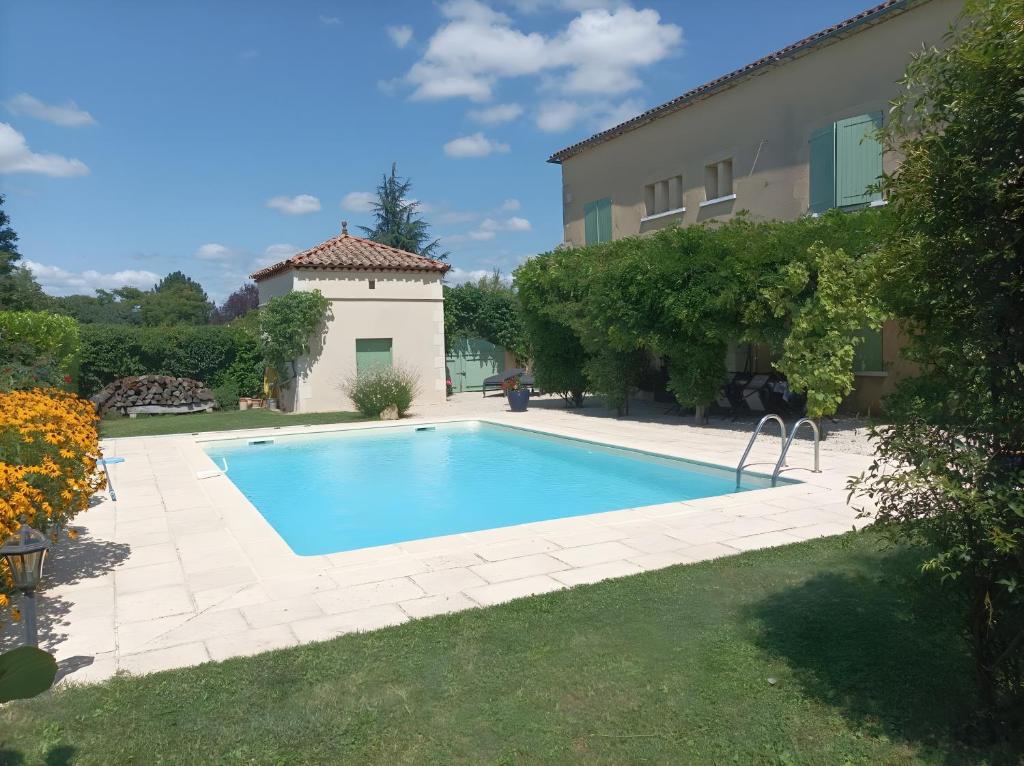a swimming pool in a yard next to a building at Le Couvent in Lagardelle