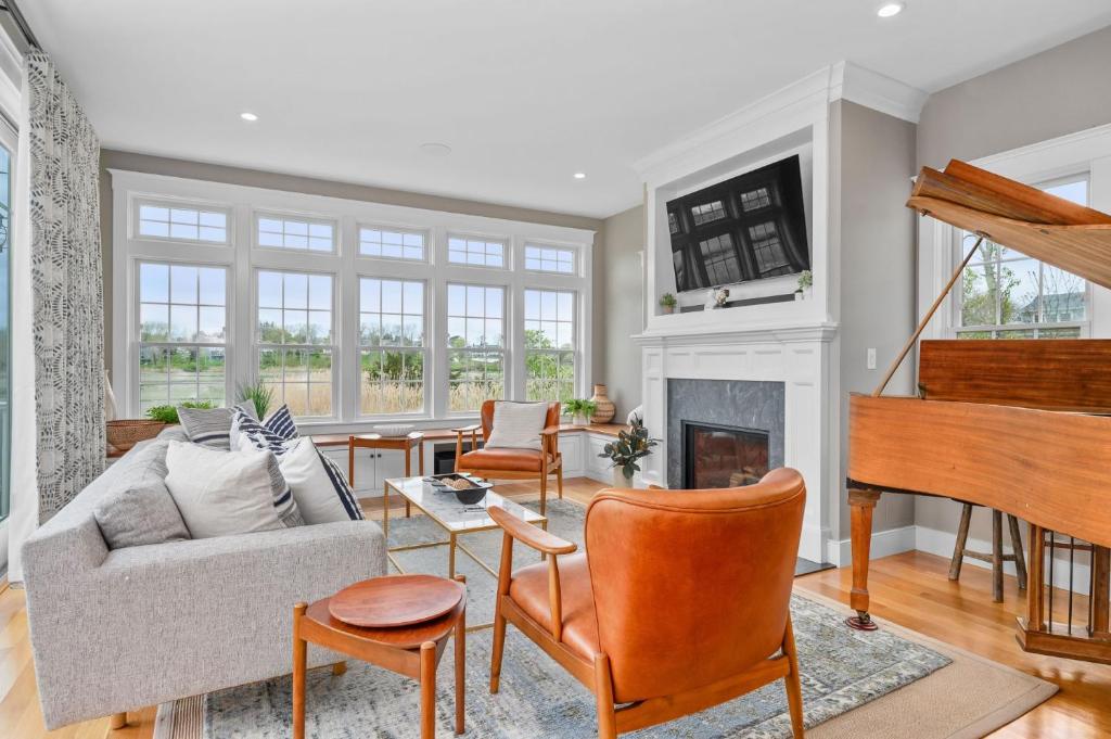 a living room with a couch and a piano at Marshside Cape Escape with Space Views in Sandwich