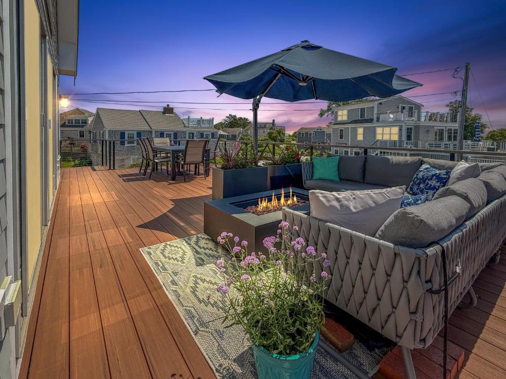 a patio with a couch and an umbrella at Slow M'Ocean – A Fresh Take on Cape Calm in Chatham