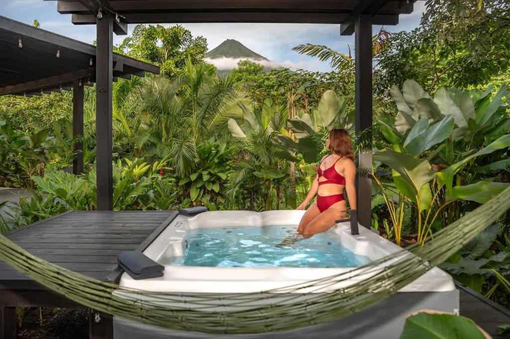 a woman sitting in a hammock in a hot tub at Rolling Green Oasis in Fortuna