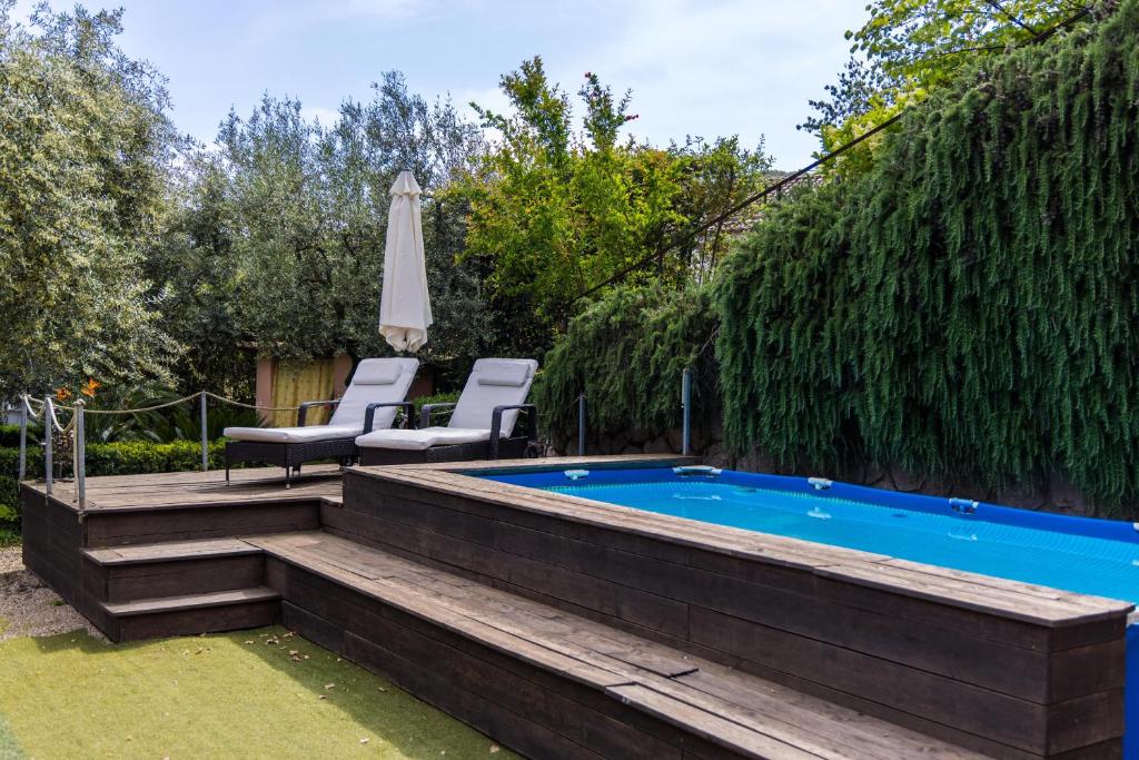 a swimming pool with two chairs and an umbrella at Villa Privata con Giardino e Piscina in Trivio