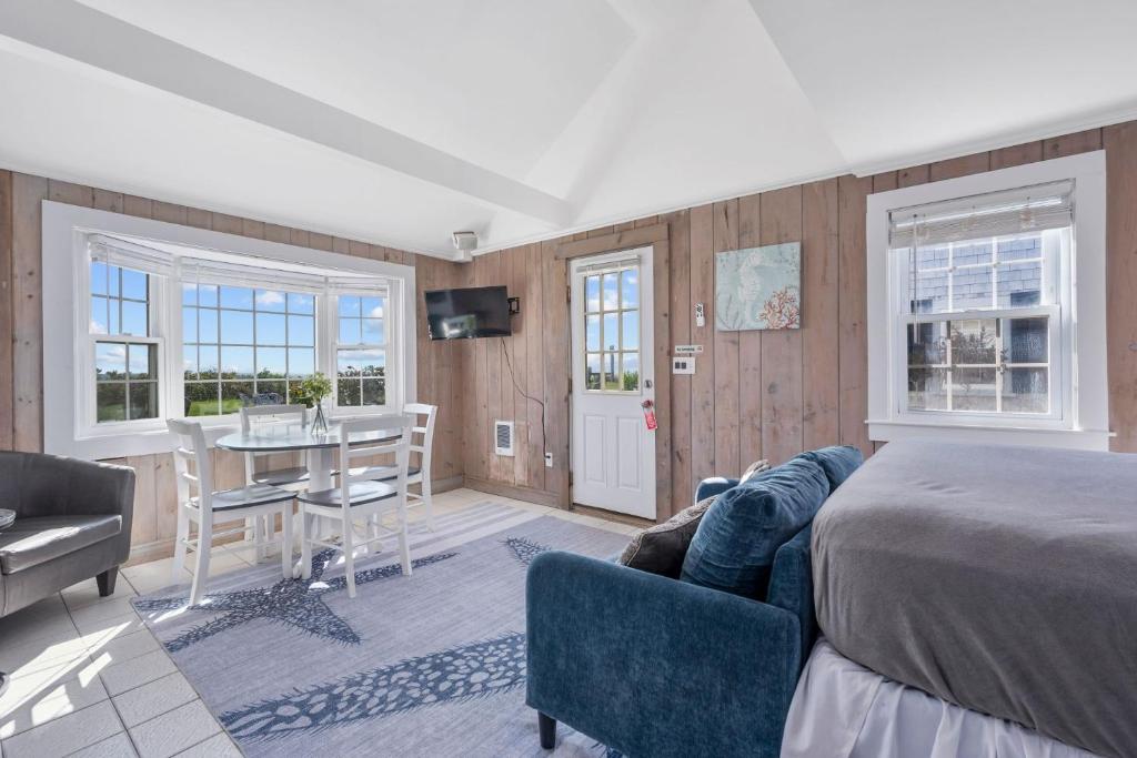 a bedroom with a bed and a desk and a table at The Shell Cottage - Where Beach Dreams Begin in South Yarmouth