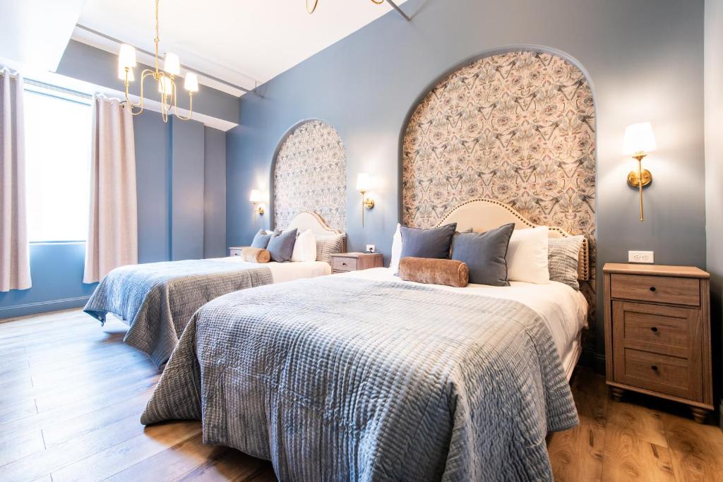 two beds in a room with blue walls at Hollyhock Suite 406 in Louisville
