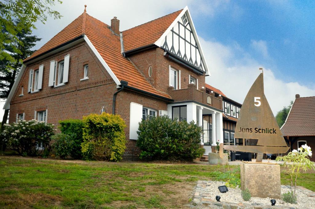 a large brick house with a sign in front of it at Schlicks Dümmer Kojen in Lembruch