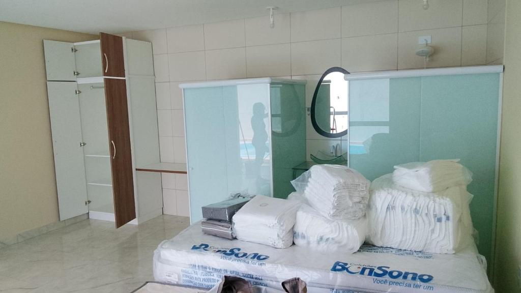 a bathroom with a pile of towels and a mirror at Cantinho do sol in Maceió