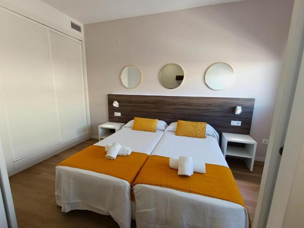 a bedroom with a large bed with three mirrors on the wall at Iberflat Apartamentos Marynton in Benicarló