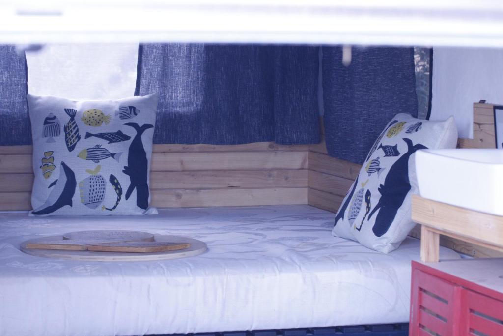 a bedroom with a bed with pillows and a wooden tray on it at La caravane plage in Pietroso