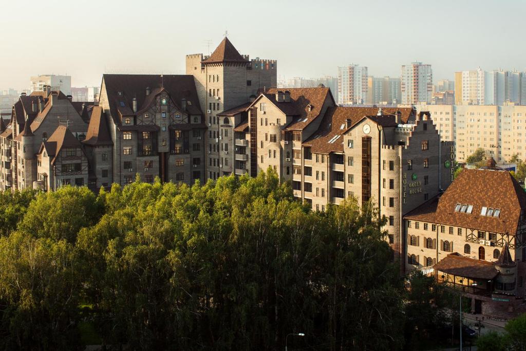 a group of buildings in a city with trees at Green House Hotel Tyumen in Tyumen