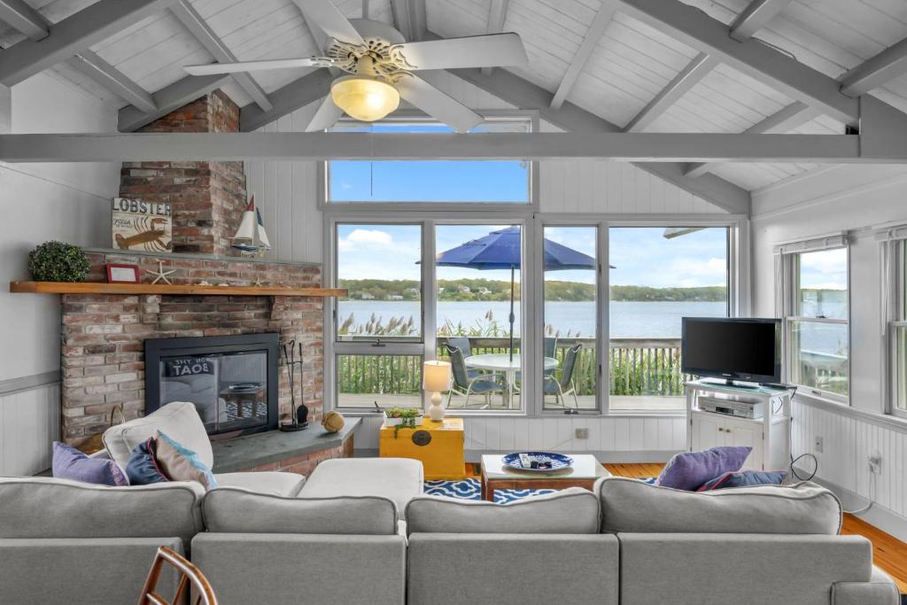 a living room with a couch and a fireplace at Charming Waterfront Escape Along the Cove in Eastham