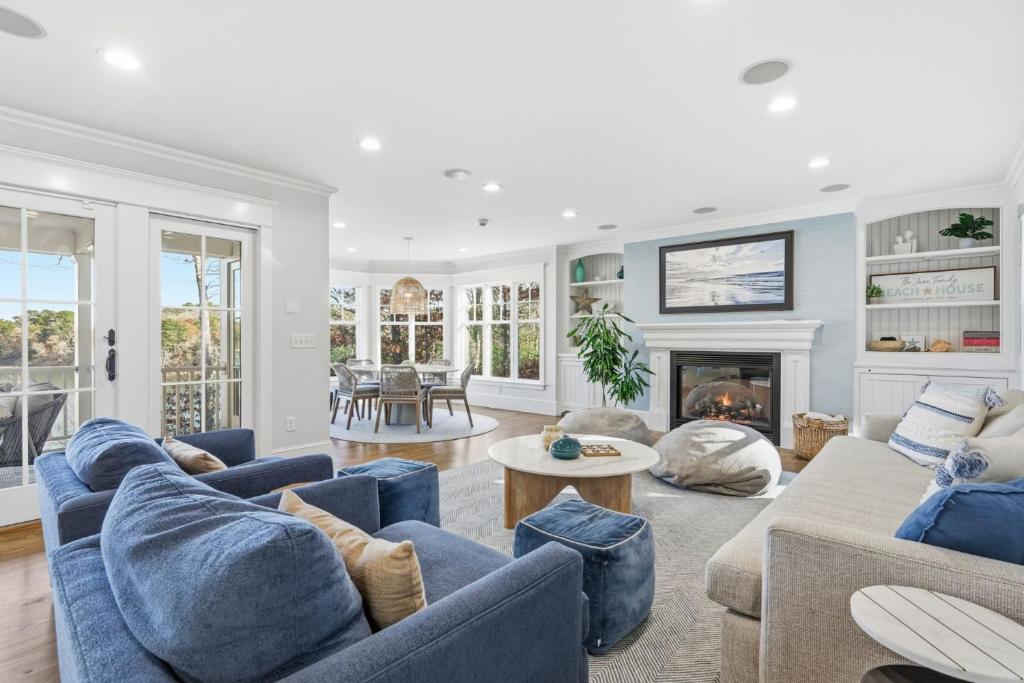 a living room with blue couches and a fireplace at Peaceful Cape Cod Escape with Pond Views Hot Tub in Sandwich