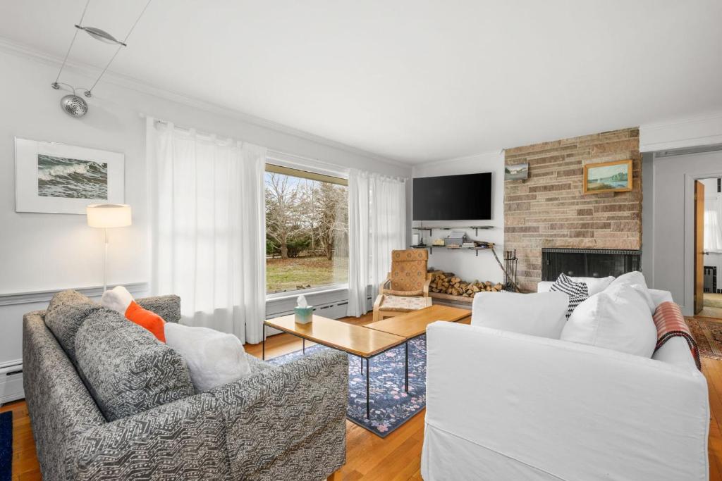 a living room with two couches and a fireplace at Relaxing Barnstable Getaway Close to the Beach in Barnstable