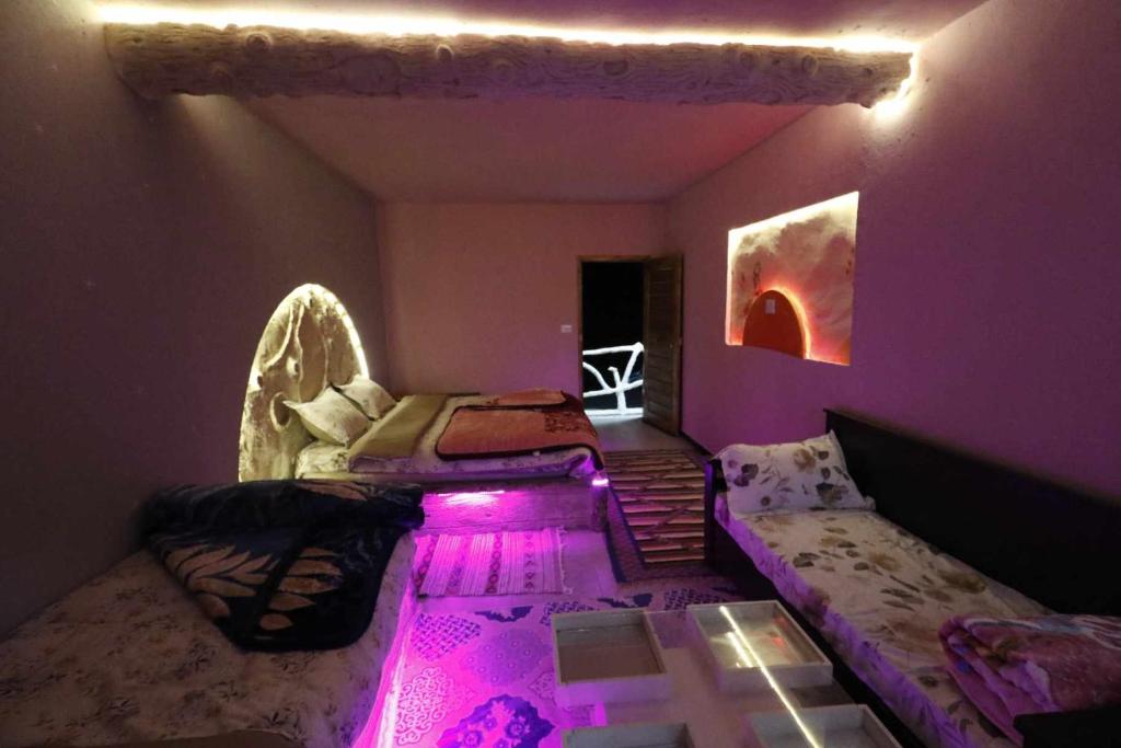 a purple room with a bed and a couch at Résidence Arinas in Al Barāwikah