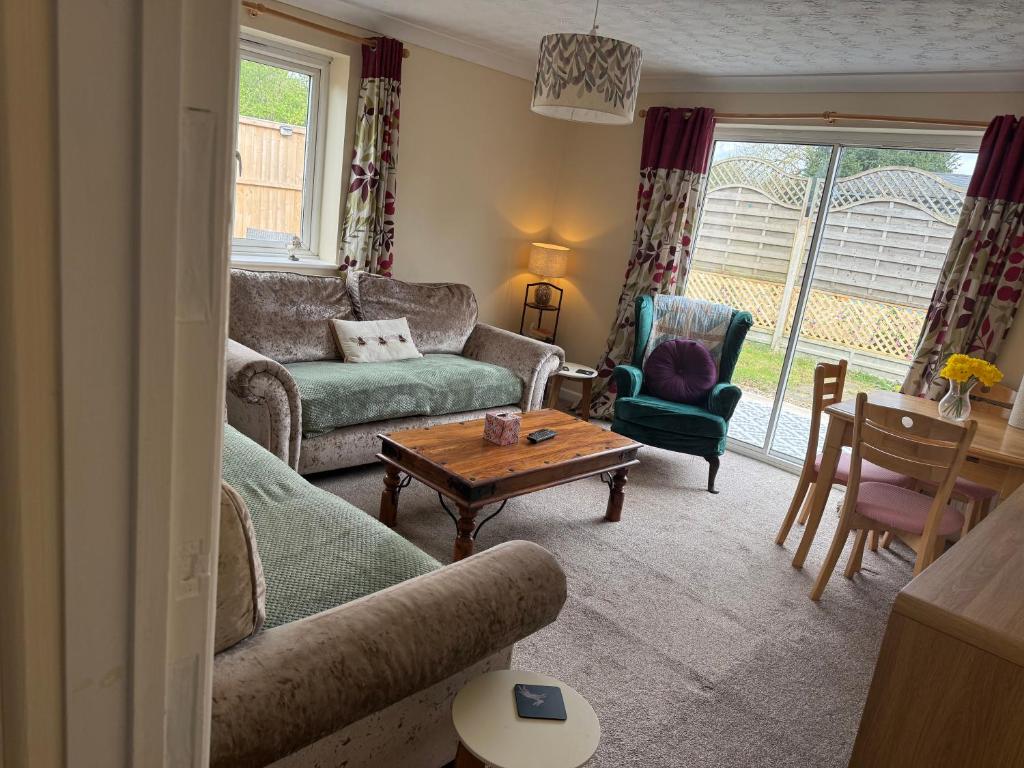 a living room with a couch and a table and chairs at The Wright Place To stay in East Harling