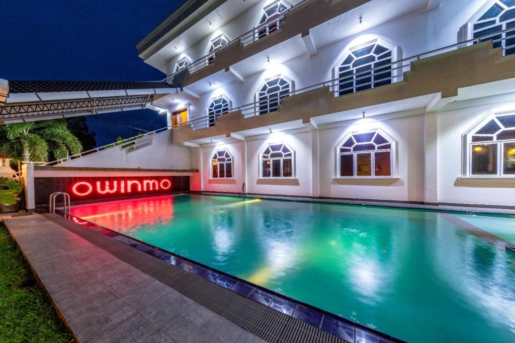 a swimming pool in a building at night at Owinmo Hotel & reception Hall in Galle