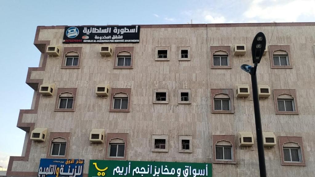 a building with a sign on the side of it at أسطورة السلطانية للشقق المخدومة درجة اقتصادية in Abha