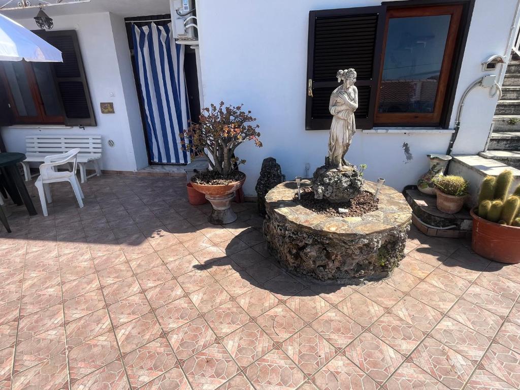 a statue of a woman sitting on a stump in a patio at Intera casa con giardino, vista mare e montagna in Maratea