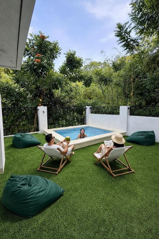 a group of people sitting in chairs by a swimming pool at Verdana Jungle Retreat Ubud in Ubud