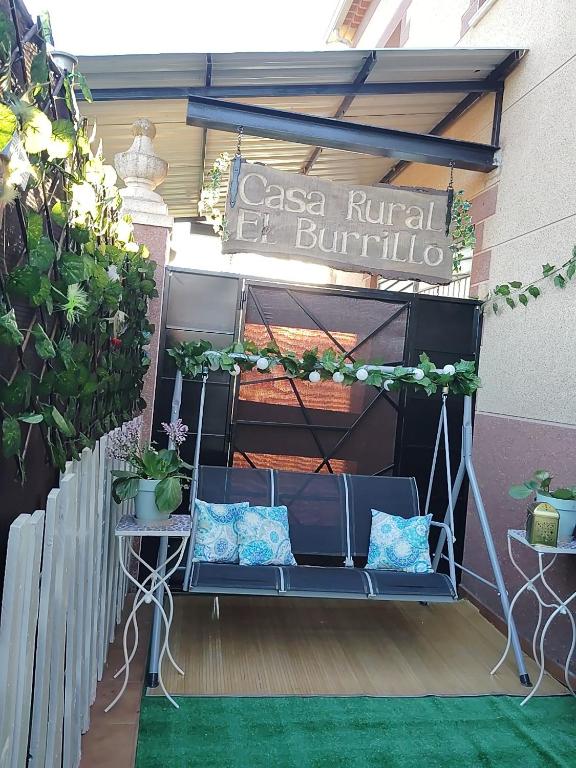 a pergola with a blue couch on a patio at casa rural El Burrillo in Cuenca
