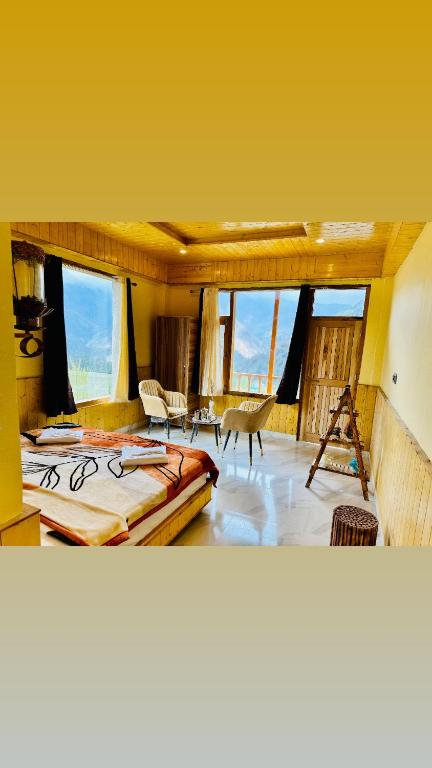 a bedroom with a large bed in a room with windows at Wildnest shangarh in Shangarh