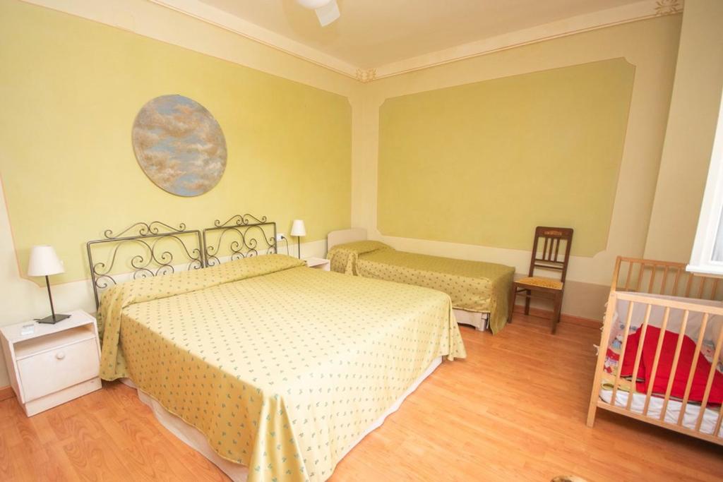 a bedroom with two beds and a crib in it at L'oleandra appartamenti in Lacona