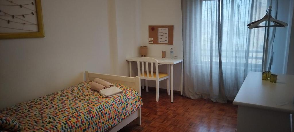a small bedroom with a bed and a desk at Vieiras House Quarto Solteiro in Barreiro