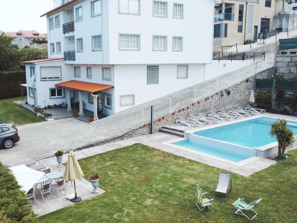 an apartment with a swimming pool next to a building at Apartamentos Avenida Areas II in Sanxenxo