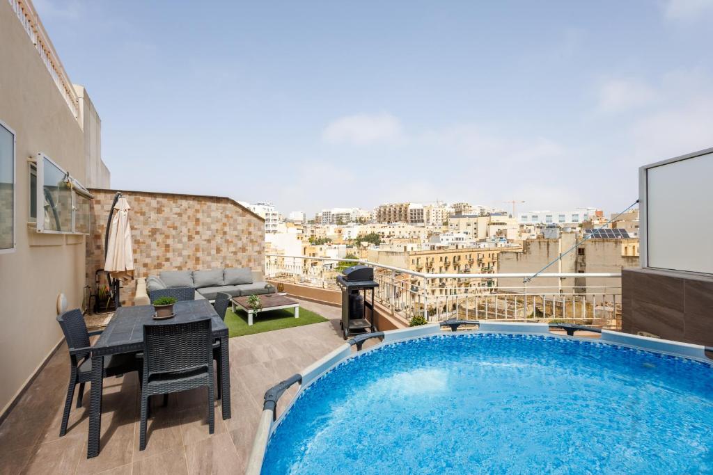 a apartment with a large swimming pool on a balcony at Bright 3BR Penthouse with Pool & BBQ in Msida by QuickTrips in Misraħ Il-Barrieri