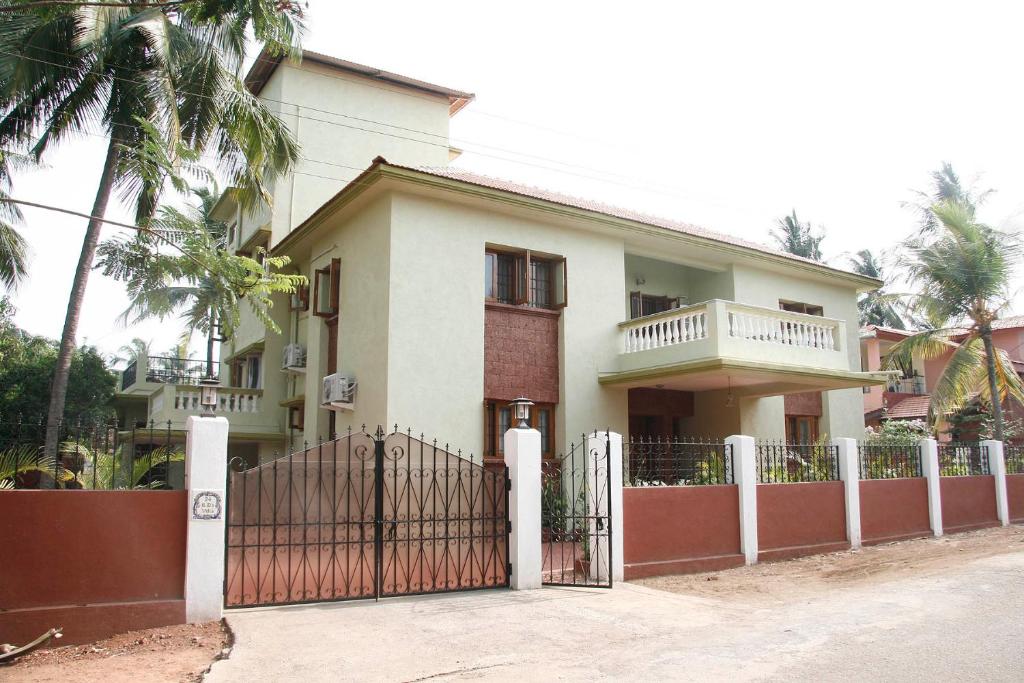 uma casa branca com um portão e uma cerca em KD's Villa - North Goa em Porvorim