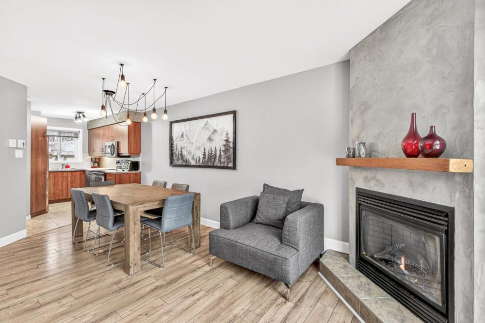 a living room with a dining room table and a fireplace at Hameau 33-104 in Stoneham